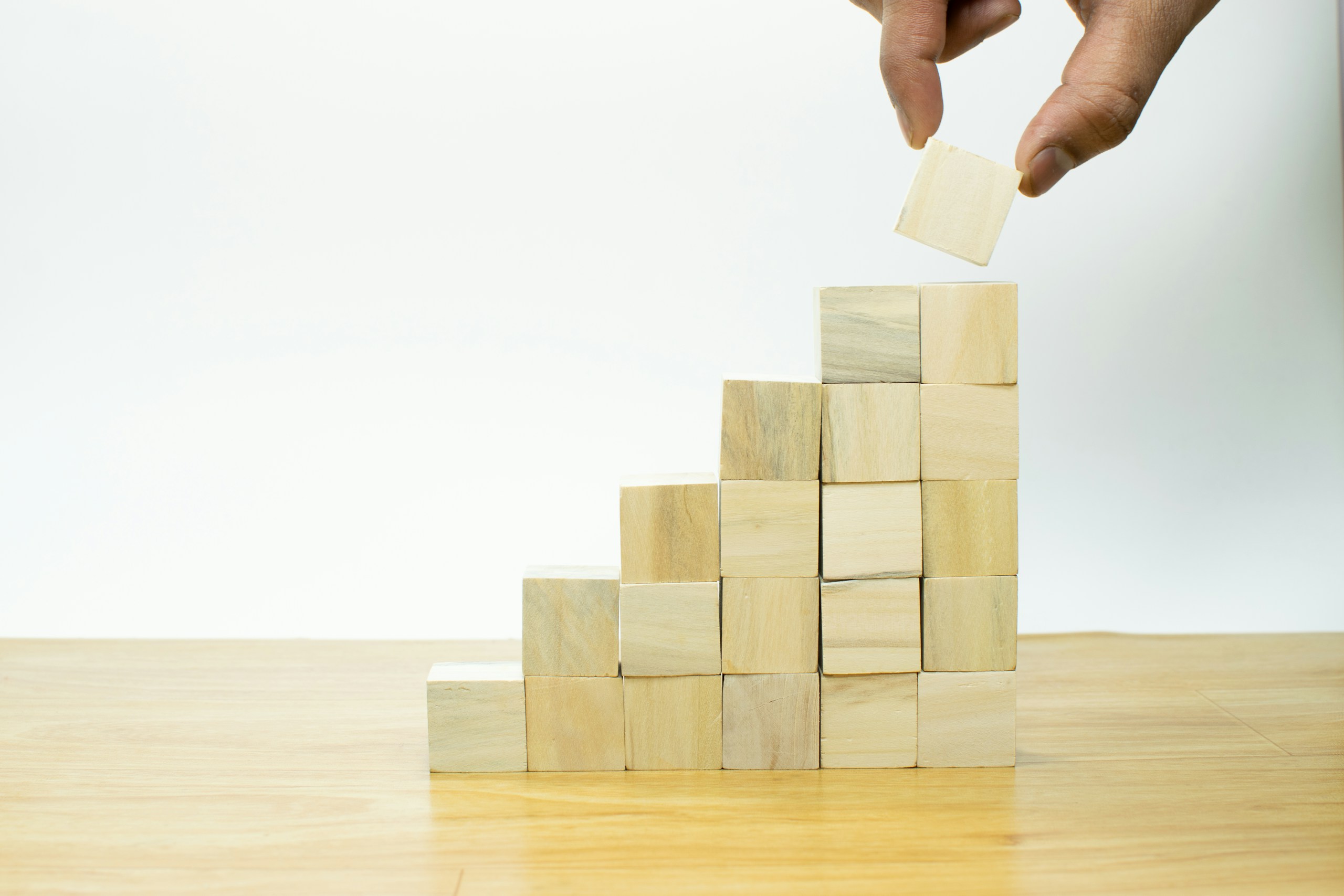 Businessman hand putting blank wooden cube block stack on white background with copy space for input text, icon, trend, creative idea, finance, leadership, strategy, business, online marketing concept